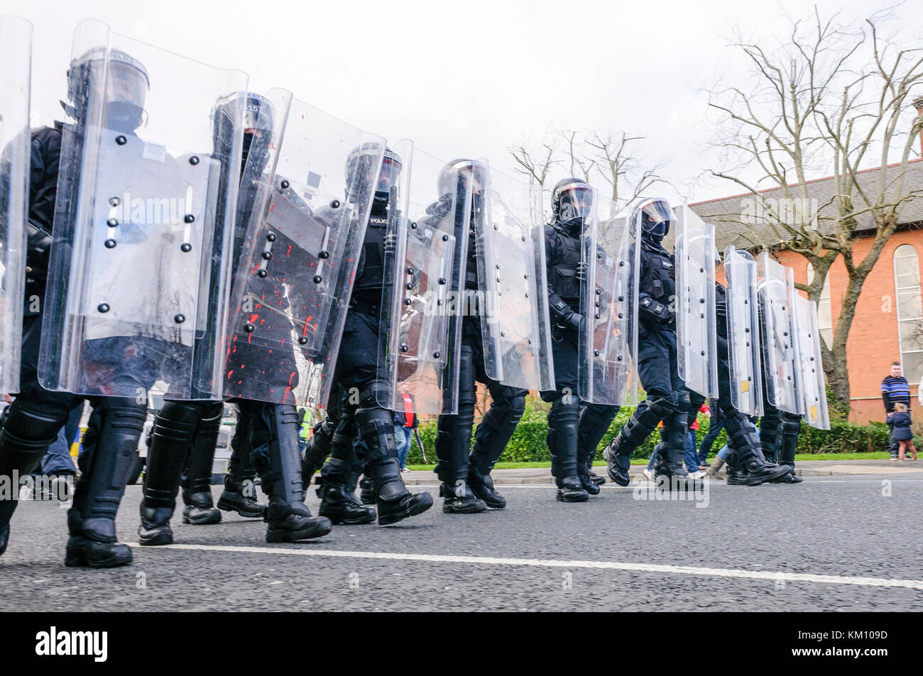 16th February 2013, Belfast, Northern Ireland, UK. PSNI officers in riot gear with Armadillo crowd control shields keep a crowd moving Stock Photo