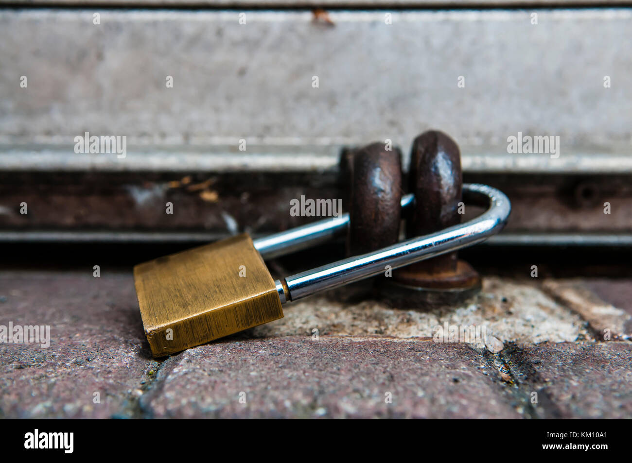 Padlock securing the shutter of a shop. Stock Photo