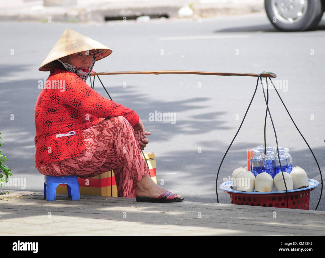 HO CHI MINH CITY, VIETNAM - JUNE 2, 2015. Unidentified street vendor selling coconuts in Ho Chi Minh City, Vietnam. Vietnam produces over 1 million to Stock Photo