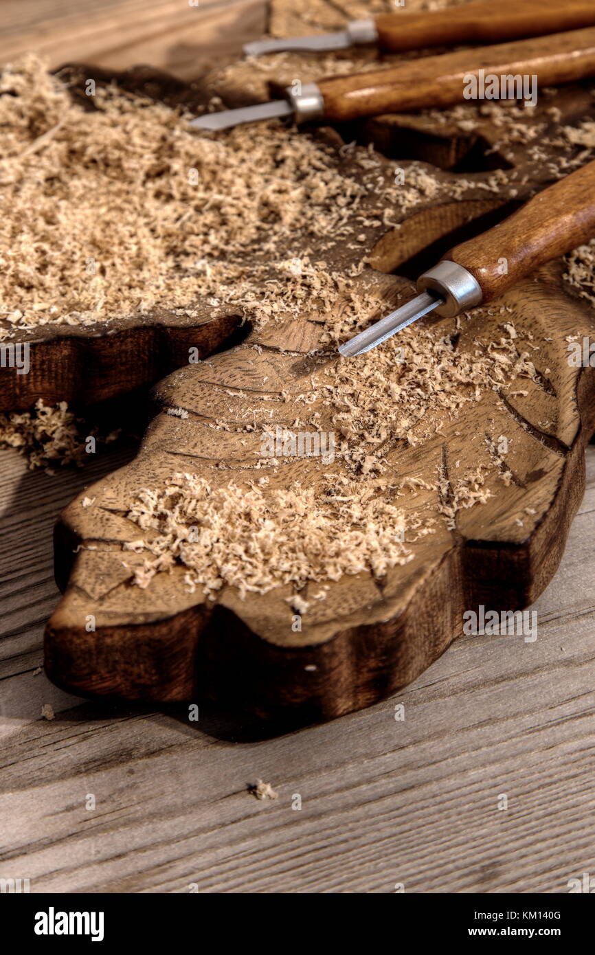 Chisel on a block of carved wood with shavings and sawdust Stock Photo