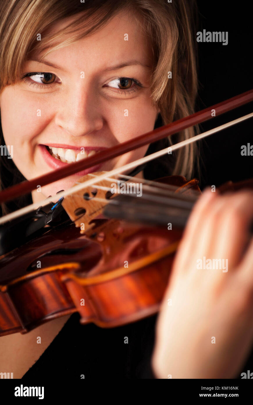 Young girl smiling and playing the violin Stock Photo - Alamy