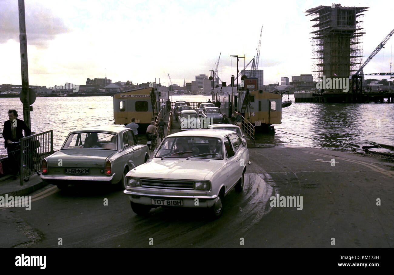AJAXNETPHOTO. 26TH SEPT, 1975 - WOOLSTON,ENGLAND. - TRAFFIC ROLLS OFF THE WOOLSTON ITCHEN RIVER CABLE FERRY WHILE TO THE RIGHT CONSTRUCTION IS UNDER WAY FOR ONE OF SEVERAL CONCRETE PILLARS THAT WILL SUPPORT THE REINFORCED CONCRETE SPANS FOR THE NEW ROAD BRIDGE.  PHOTO:JONATHAN EASTLAND/AJAX REF:3 EPS 007 Stock Photo