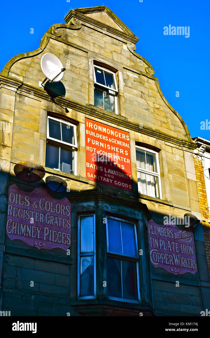 Old Painted Advertising Signs on upper floors of town centre shop in Bridgend,now occupied as Nali's Barber Shop. Stock Photo