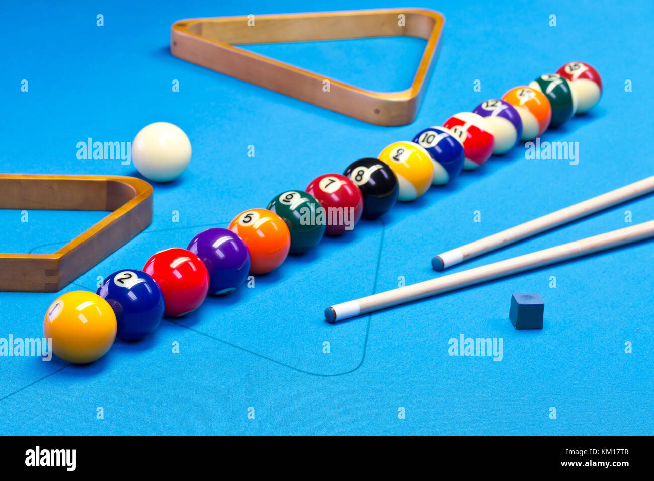 Billiard pool game balls lined up on billiard table with blue cloth with cues, racks, and chalk Stock Photo
