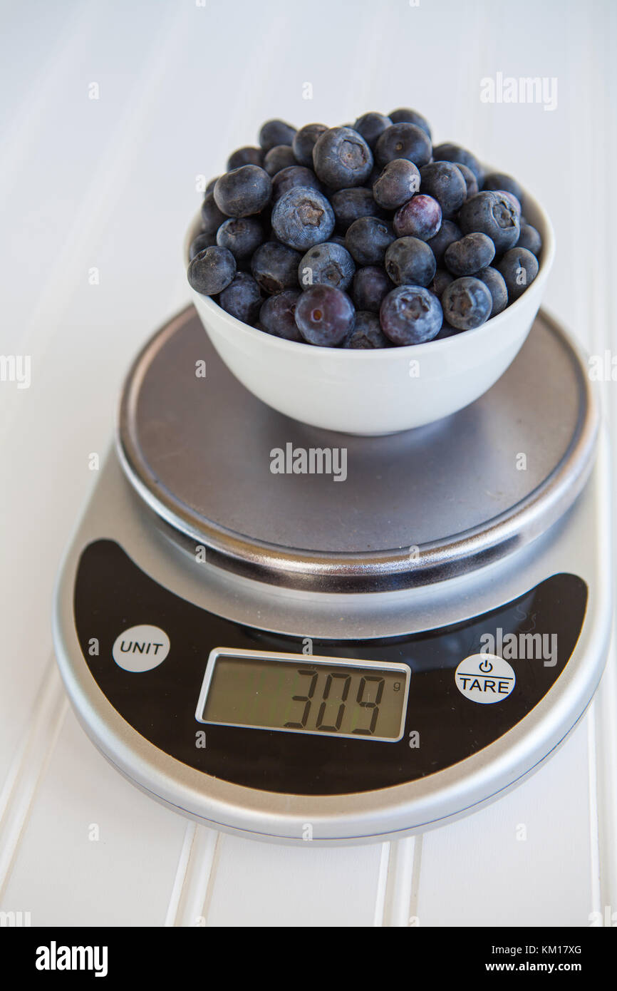 Blueberries being weighed on digital food scale Stock Photo