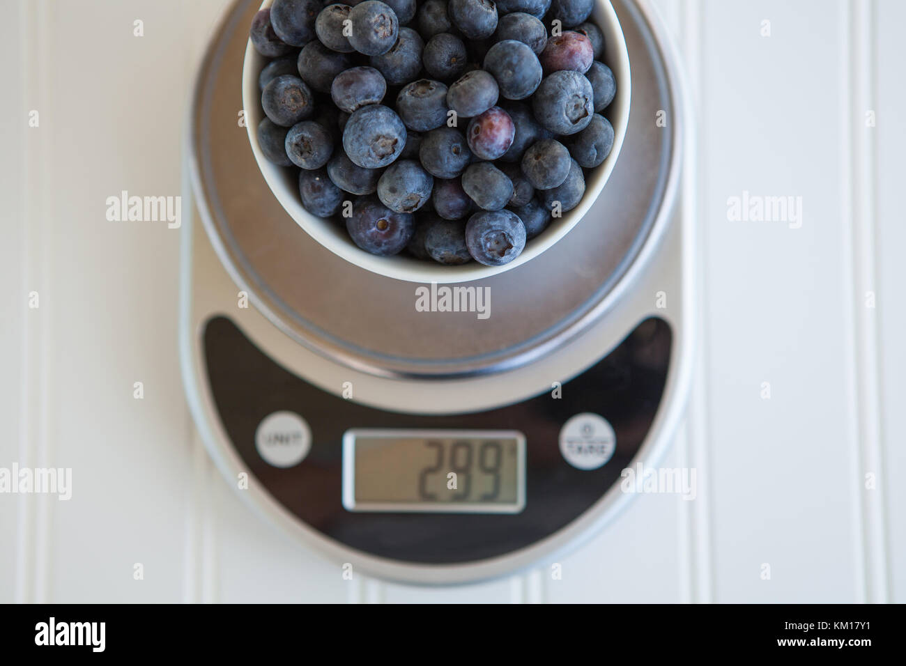 Blueberries being weighed on digital food scale Stock Photo