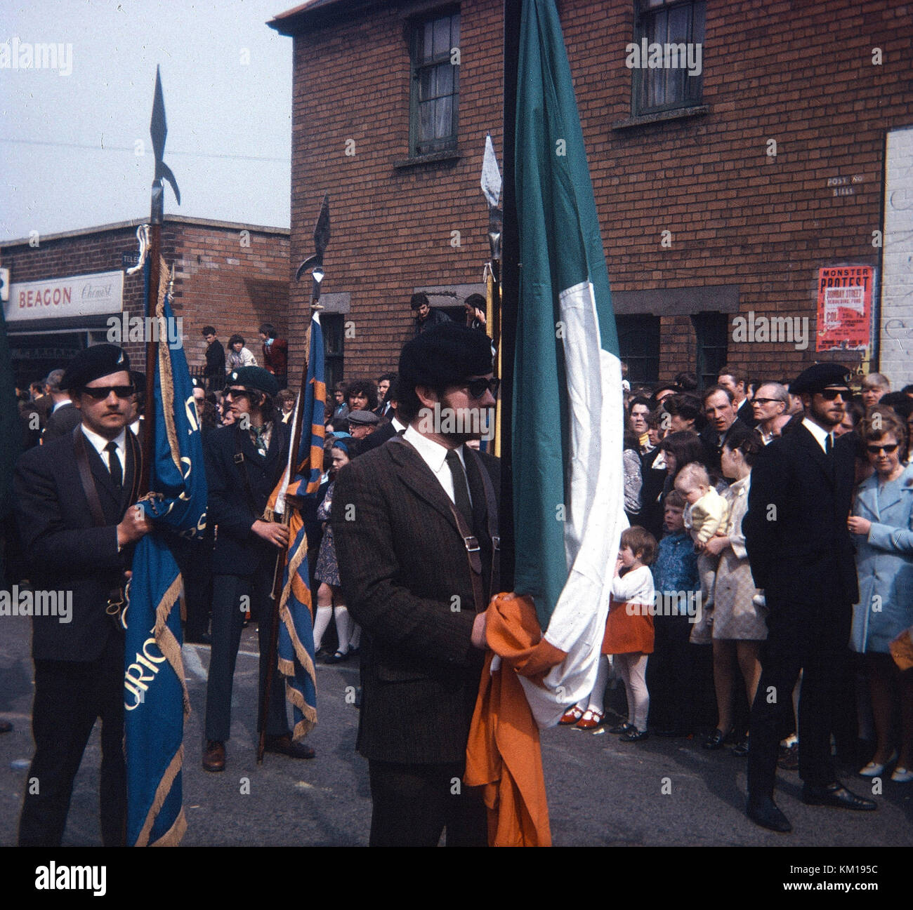 IRA colour party and republican easter parade on beechmount avenue west Belfast 1970. This easter parade signalled the split between the official and provisional IRA. The official IRA used stick on easter lillies (so became known as the stickies) and the provisional IRA wore pin on badges. This is the pin on parade Stock Photo