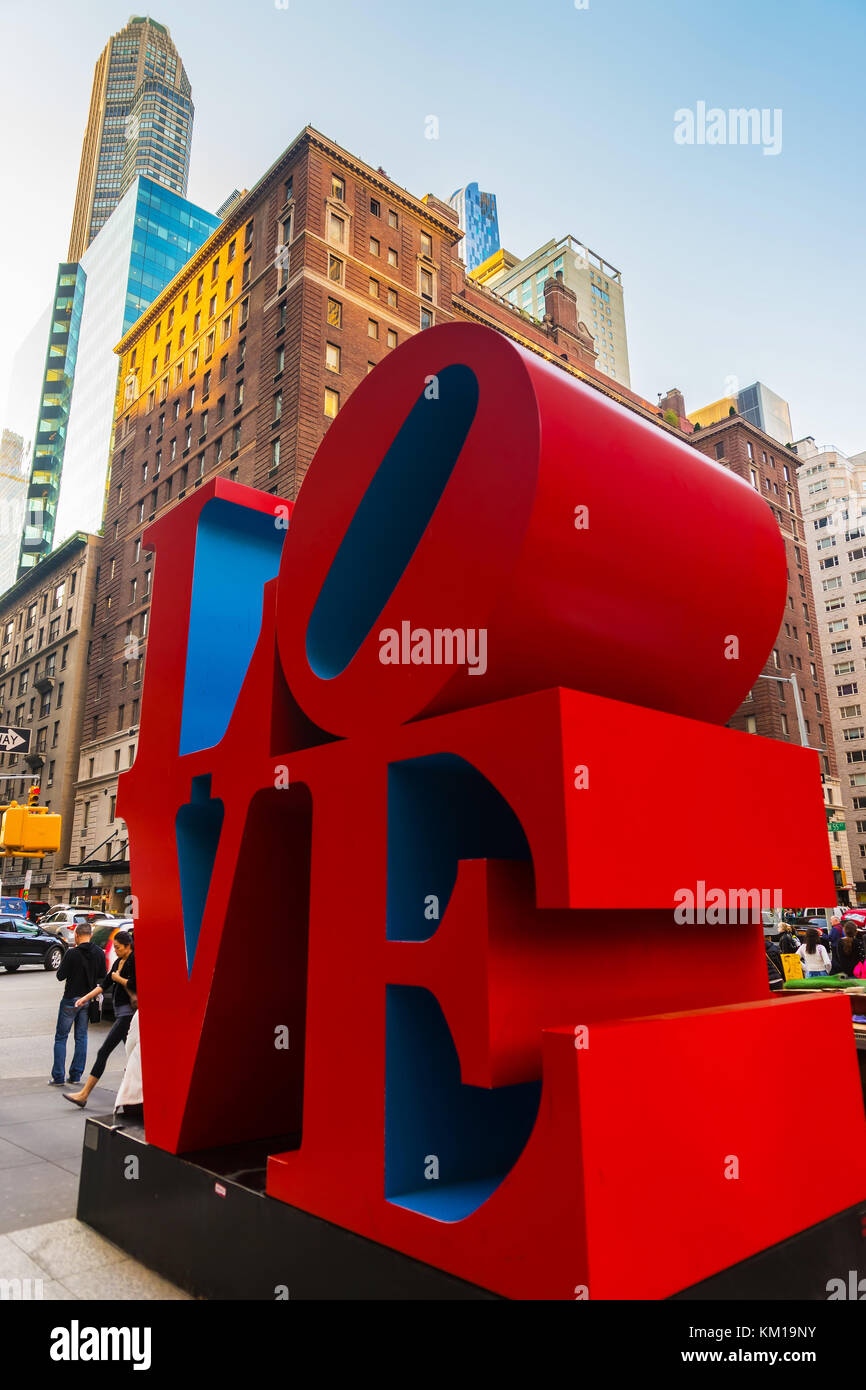 New York, USA - May 6, 2015: Love sculpture by American artist Robert Indiana and tourists passing by in Midtown Manhattan in New York, NYC, USA. The  Stock Photo