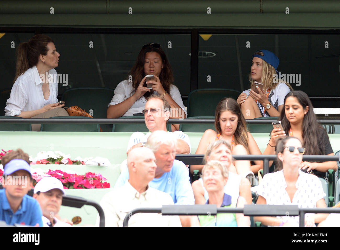 KEY BISCAYNE, FL - MARCH 28: Tennis player Eugenie Bouchard looks Smitten with someone on her cell phone while she watches Grigor Dimitrov of Bulgaria defeat Andy Murray of Great Britain day 8 of the Miami Open presented by Itau at Crandon Park Tennis Center on March 28, 2016 in Key Biscayne, Florida.   People:  Eugenie Bouchard Stock Photo