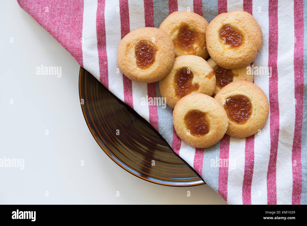 Jam drop cookies on serving plate with teatowel Stock Photo