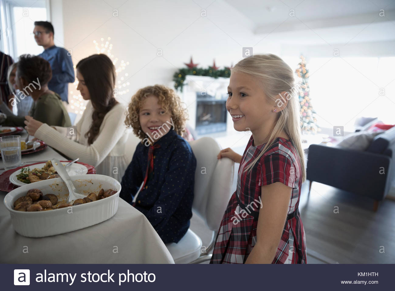 Brother and sister enjoying family Christmas dinner at table Stock Photo