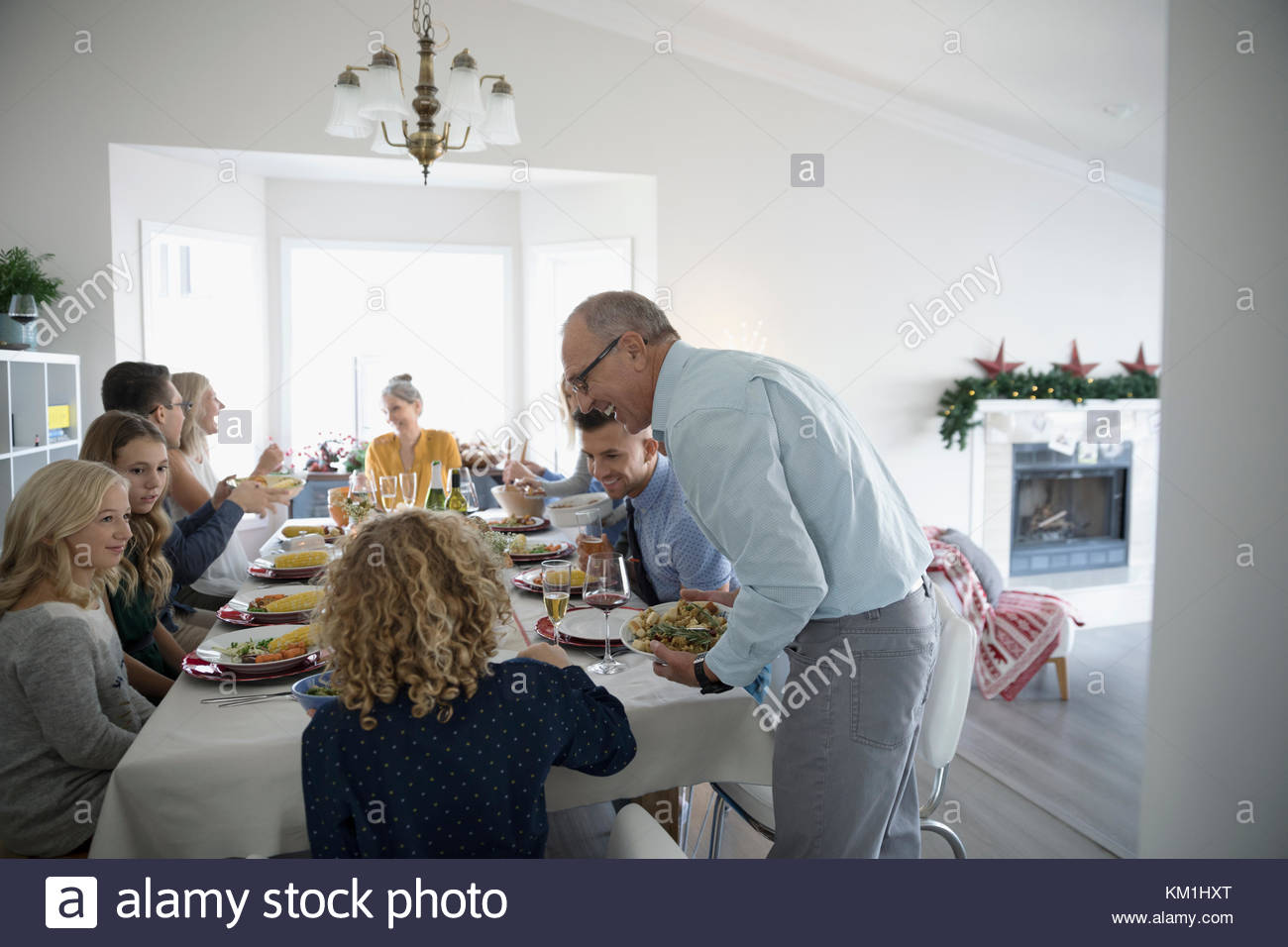 Multi-generation family enjoying Christmas dinner at dinner table Stock