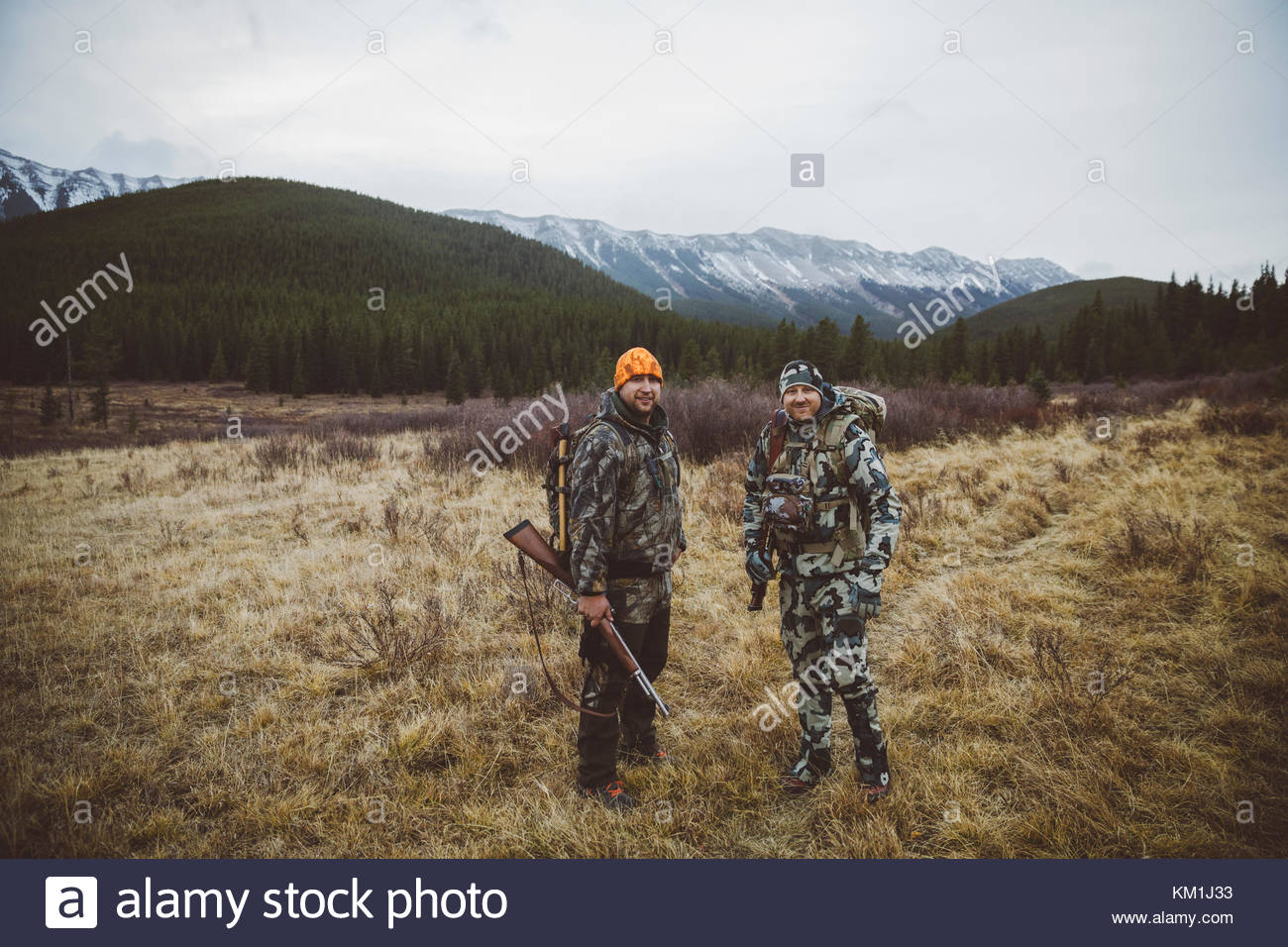 Portrait smiling, confident male hunters with hunting rifles in remote