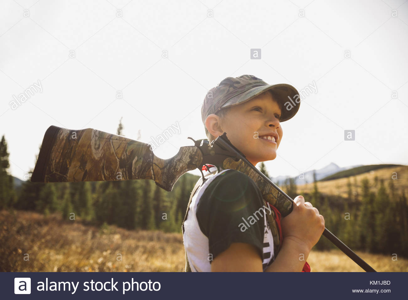 Smiling boy hunter holding hunting rifle Stock Photo Alamy
