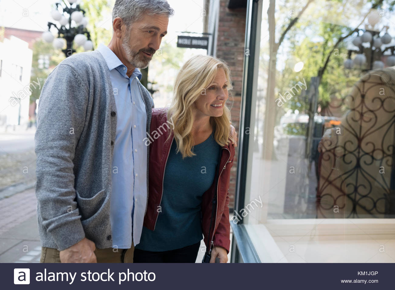 Mature couple window shopping at storefront Stock Photo