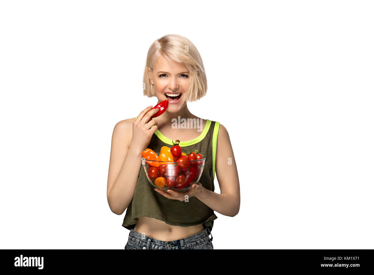 Young woman holding bowl of vegetables pepper and tomatoes isolated on white background Stock Photo