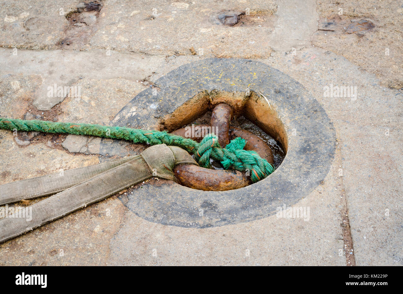 Rope tied to metal sunken mooring ring at the dock in Teignmouth, Devon, England, UK Stock Photo