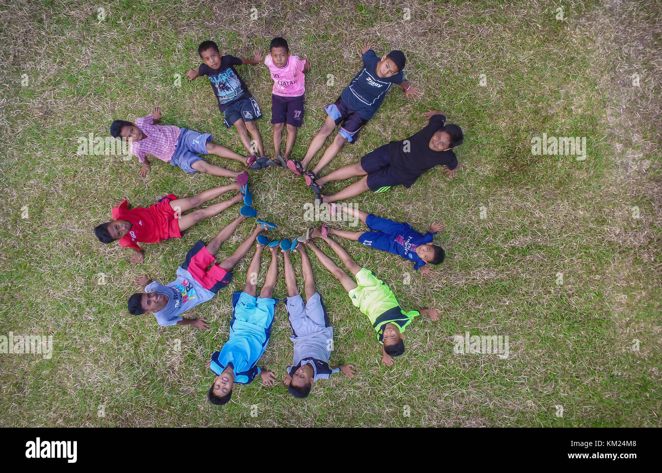 Children poses in circle after playing soccer in their village in South Sulawesi Stock Photo