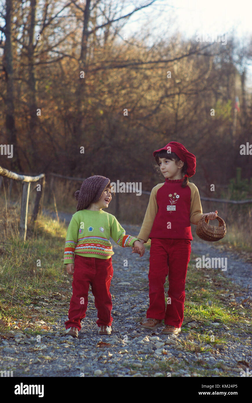 Two little kids (sisters) walking hand in hand and having fun. Vintage style, autumn season Stock Photo