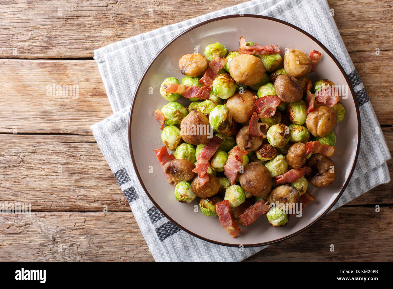 Fried chestnuts, brussels sprouts and bacon closeup on a plate
