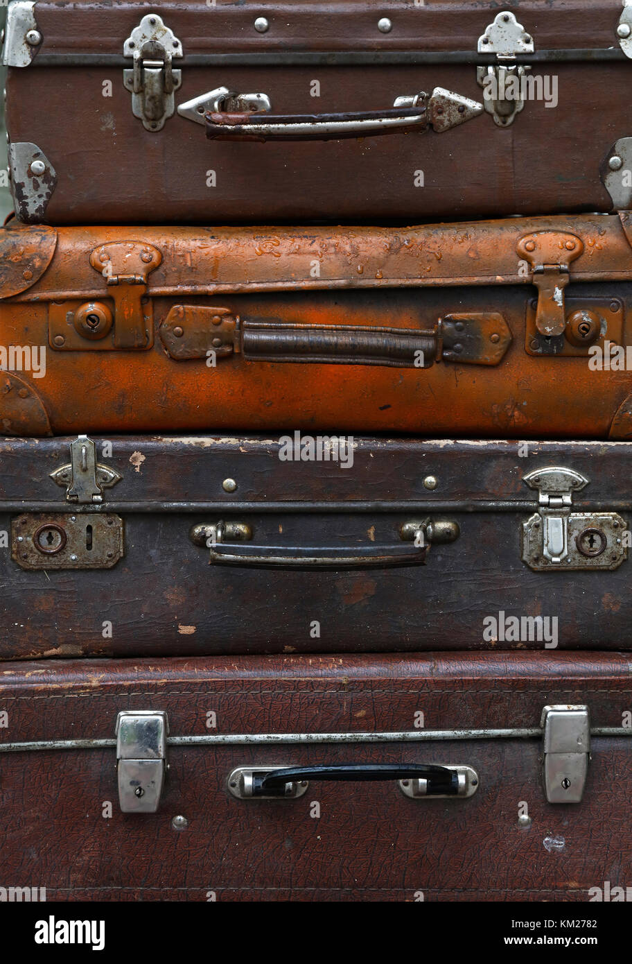 Stack of four old vintage antique grunge travel luggage brown leather suitcase trunks, close up