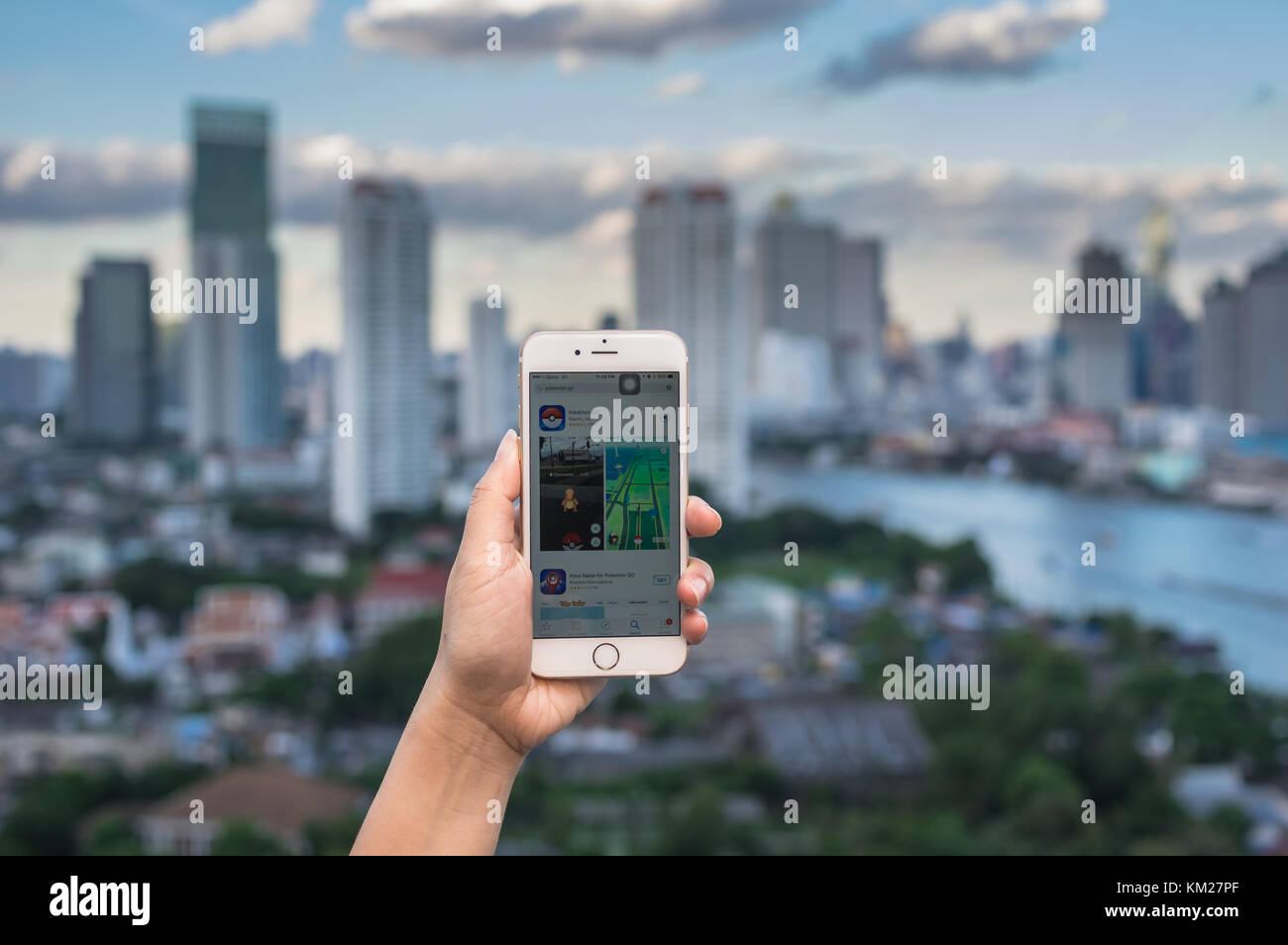 Bangkok, Thailand - July 31, 2016 : Hand holding Apple iPhone6 mobile phone showing the Pokemon Go application at screen over the bangkok cityscape ph Stock Photo