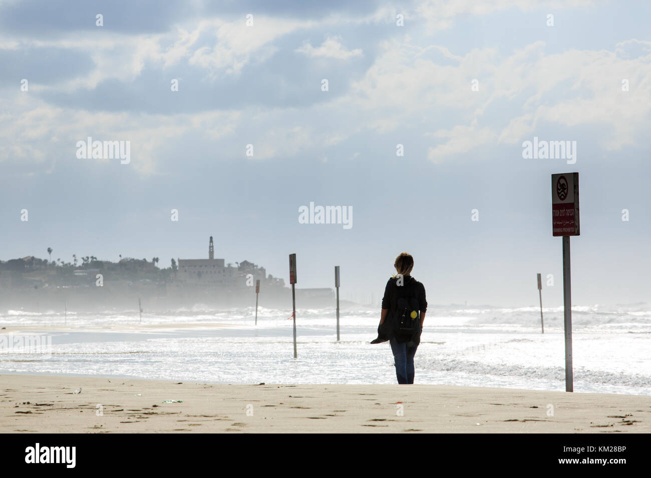 Woman on the beach on a windy day in Tel Aviv, Israel Stock Photo