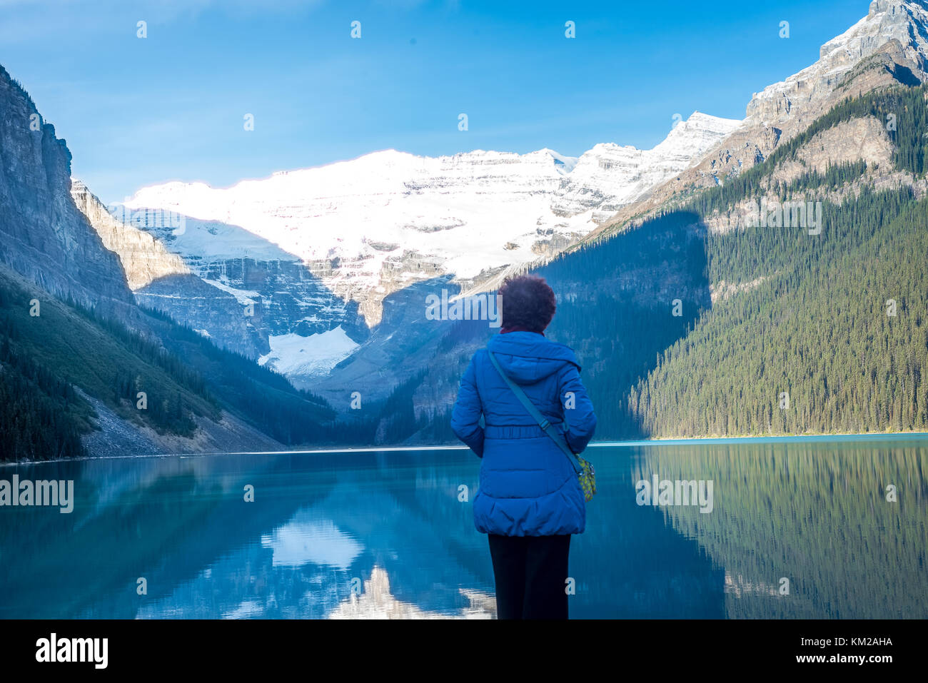 Woman enjoying the beauty of lake louise and rocky mountain Stock Photo ...