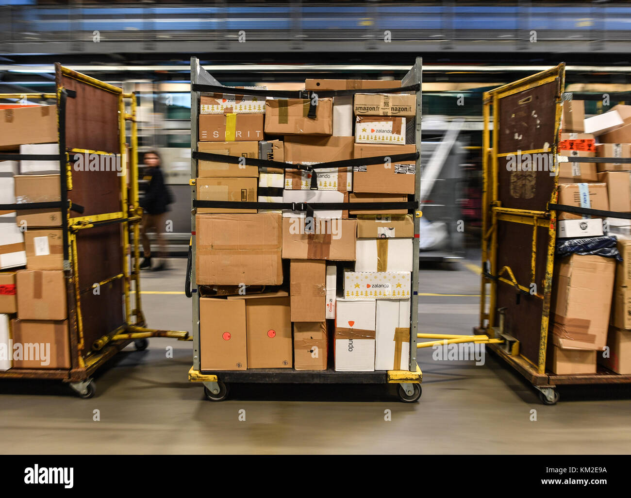 Ruedersdorf, Germany. 30th Nov, 2017. Parcels lie on transport trolleys and  are being driven across the hall of the DHL parcel centre in Ruedersdorf,  Germany, 30 November 2017. The employers of the