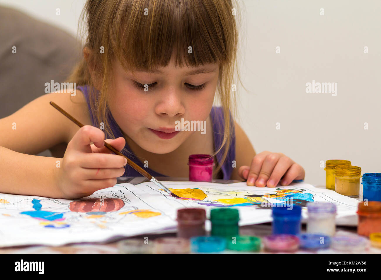 Cute little girl painting with brush and colourful paints Stock Photo ...