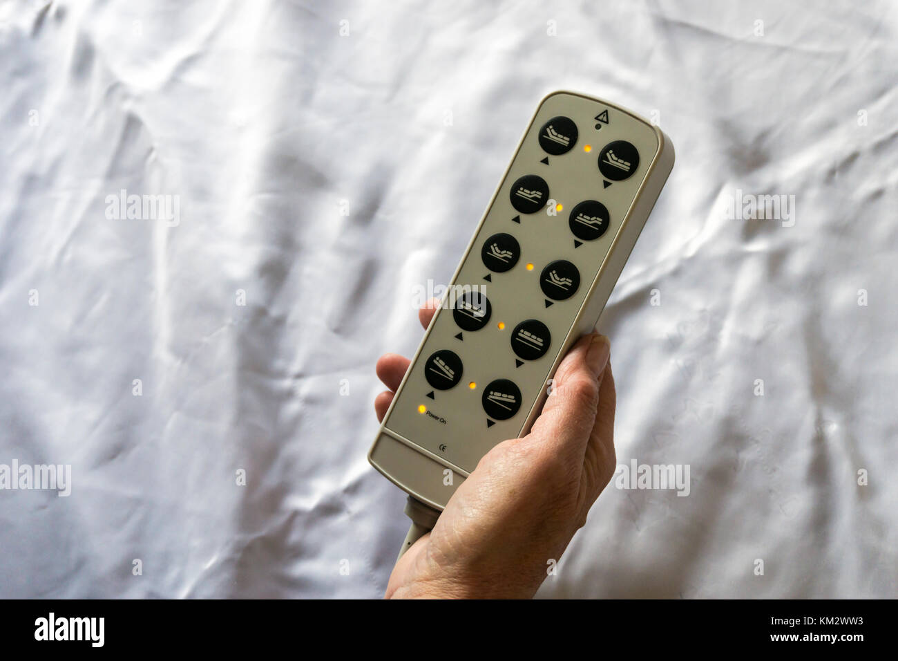 Woman holding the controls for a hospital bed showing the different