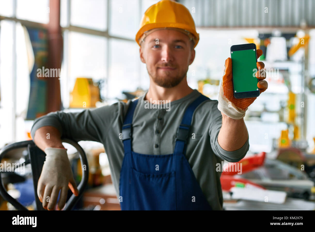 Young Workman Presenting Mobile App Stock Photo