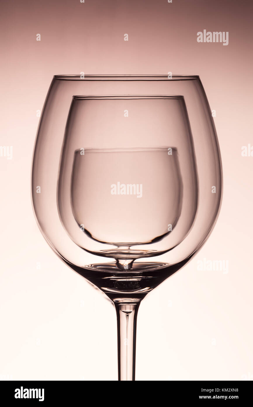Three empty wineglass for red wine on diffusion lit background in abstract   composition with reflection, advertizing shot for restaurant, winemaking Stock Photo