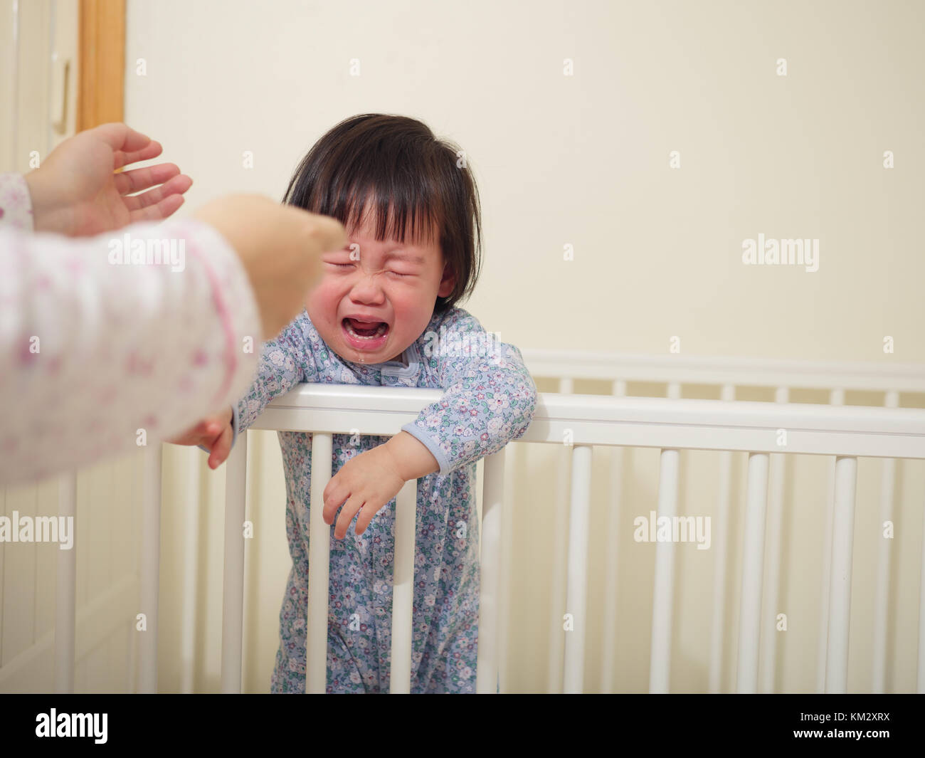 Crying Baby girl in cot bed Stock Photo Alamy