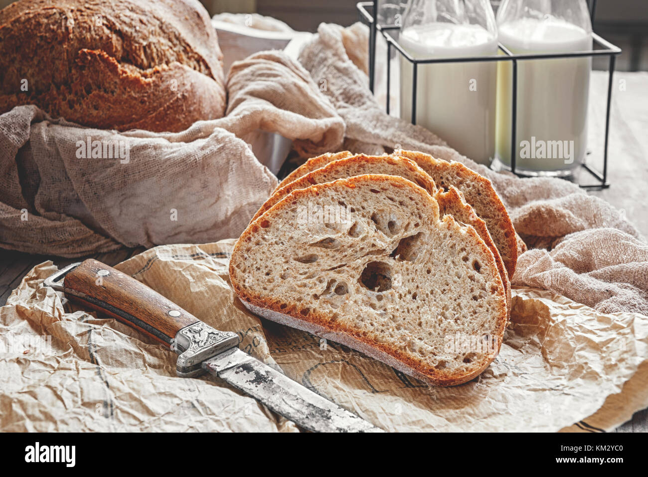 A beautiful loaf of sourdough bread from white wheat on a plate on a linen edge. Homemade pastries. Stock Photo