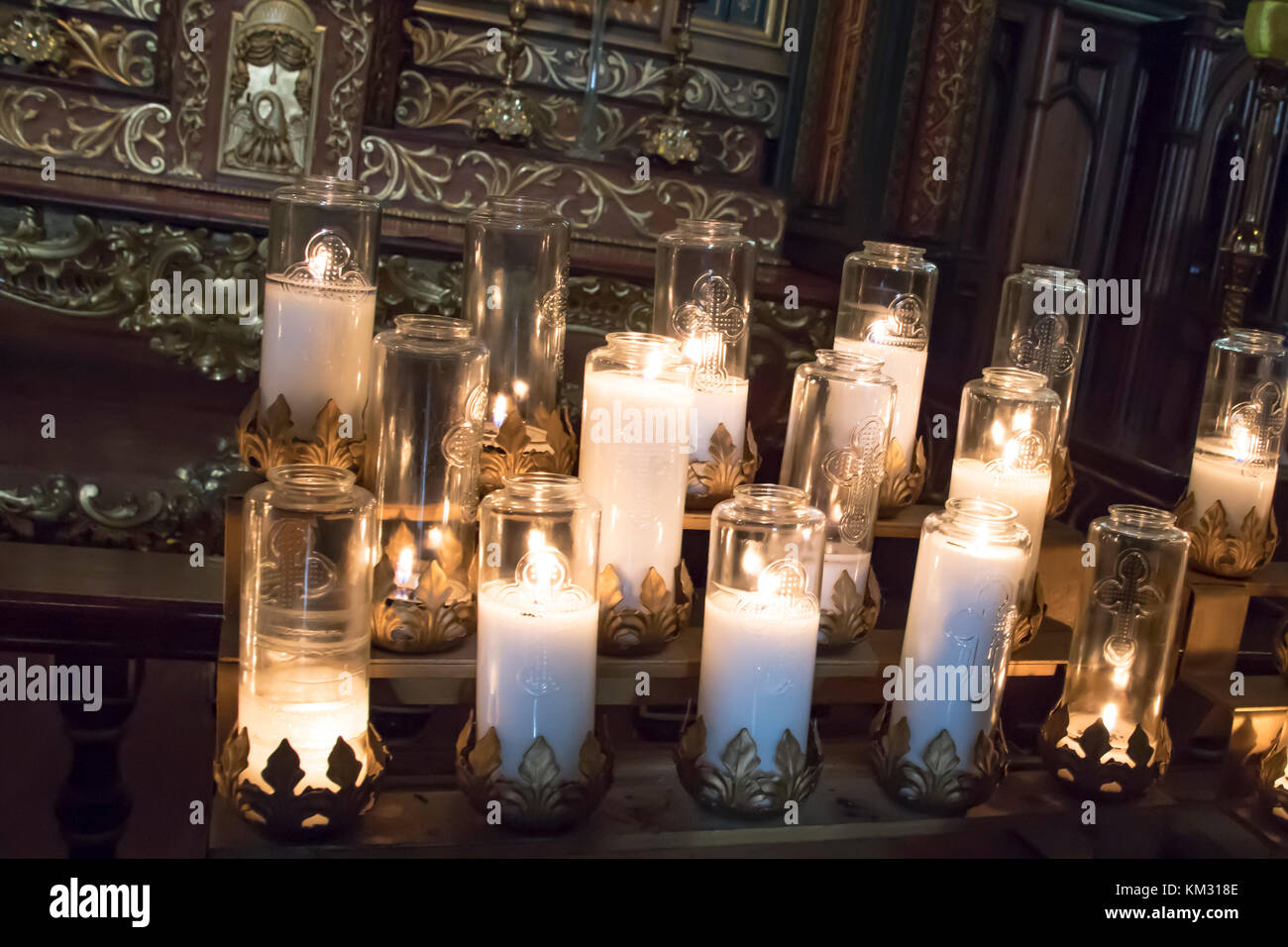 Prayer candles burnign in glass holders inside Basilica of Notre Dame