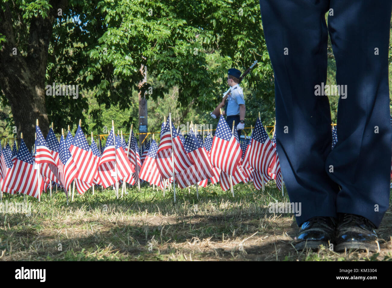 Honor guard standing watch over a field of American flags honoring the US military Stock Photo