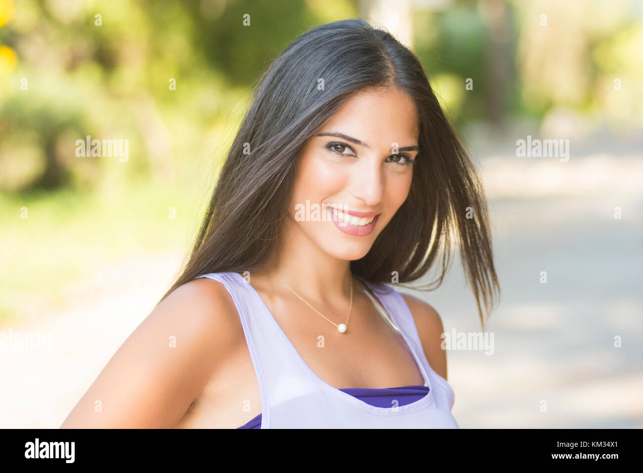 Beautiful young woman smiling outdoors Stock Photo - Alamy