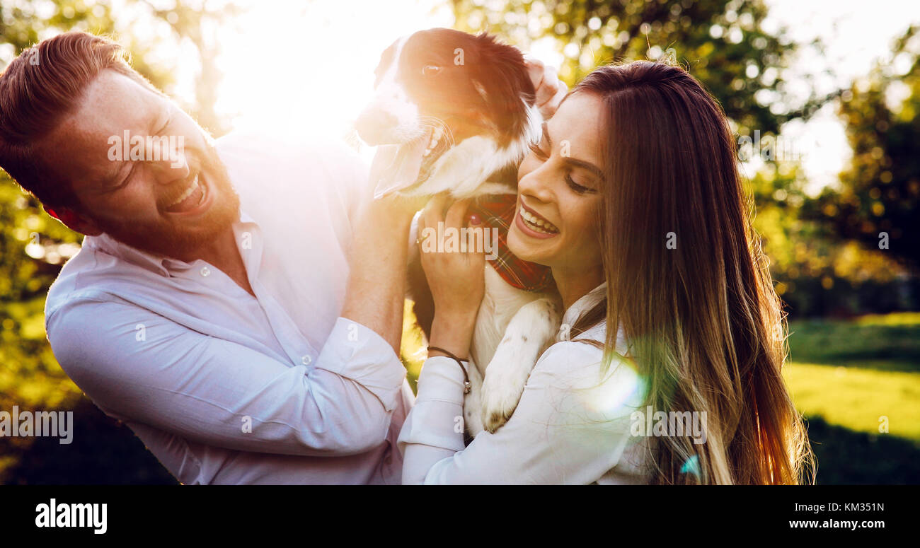 Romantic couple in love walking dogs in nature and smiling Stock Photo