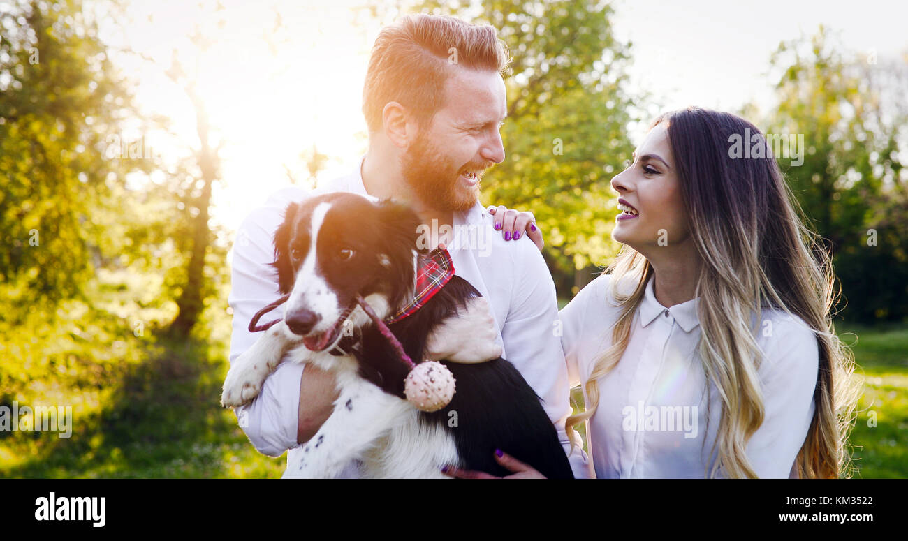A young couple walking a dog in the park Stock Photo - Alamy