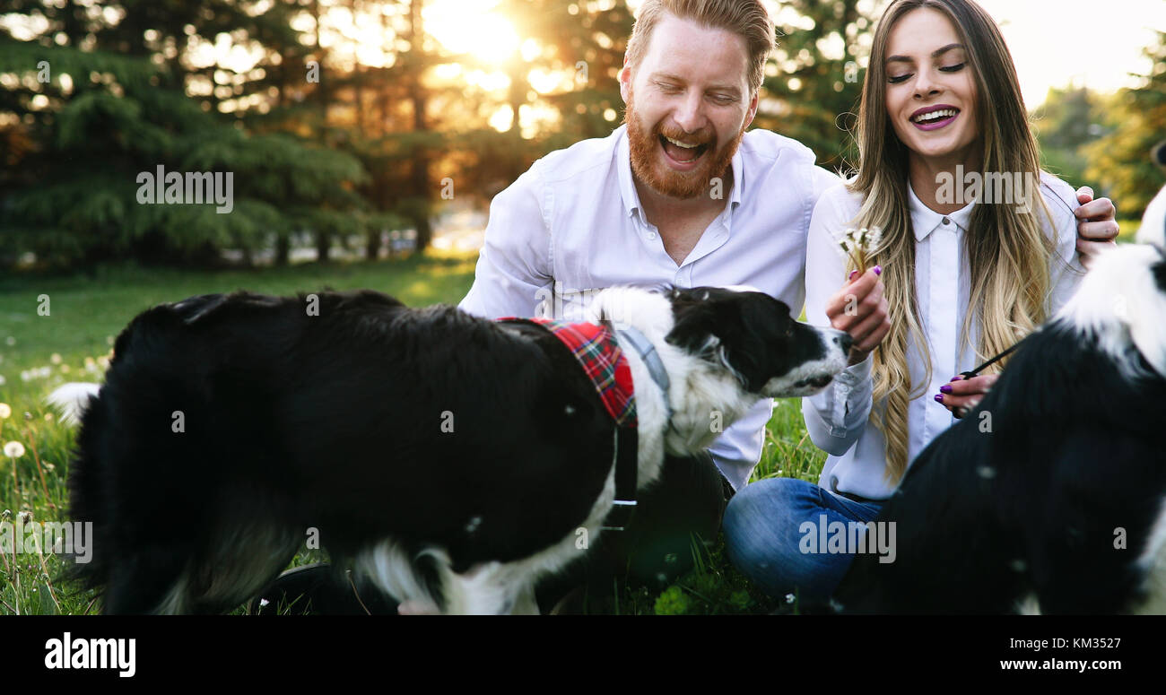 A young couple walking a dog in the park Stock Photo - Alamy