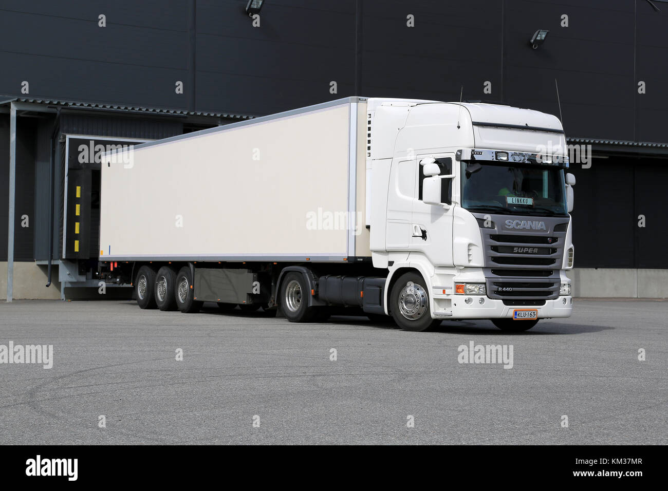 TURKU, FINLAND – APRIL 26, 2014: White Scania R440 truck unloading by a warehouse. According to Statistics Finland, a total of 71 million tonnes of go Stock Photo