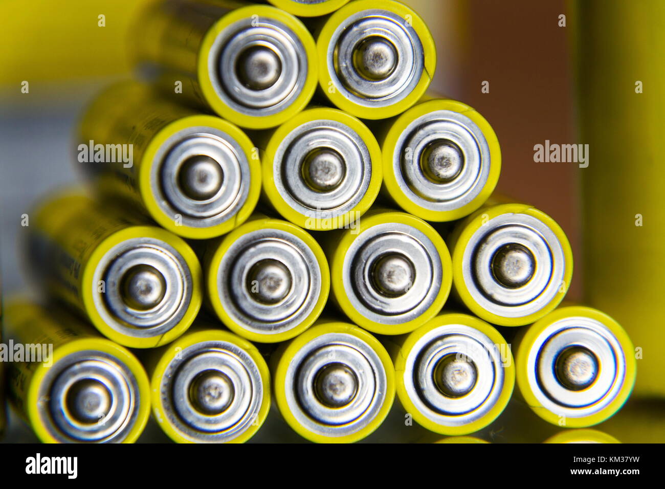 Stack of yellow AA batteries close up abstract coloured background