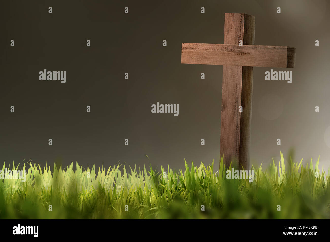 Wooden christian cross on green grass with blur background Stock Photo