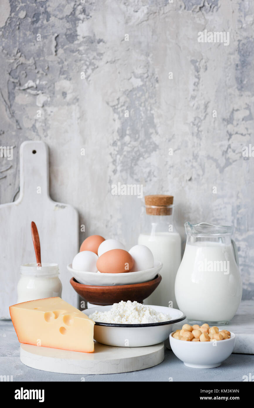 Dairy products on marble table over concrete background. Cheese, farmers cheese, milk, yogurt, sour cream, eggs and smoked cheese. Organic farmers dai Stock Photo
