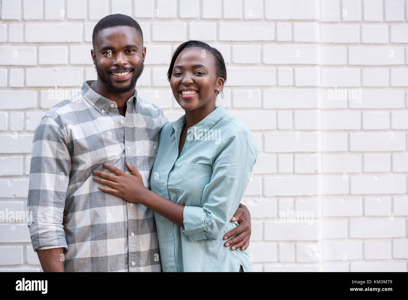 Young African couple smiling while standing together in the city Stock Photo