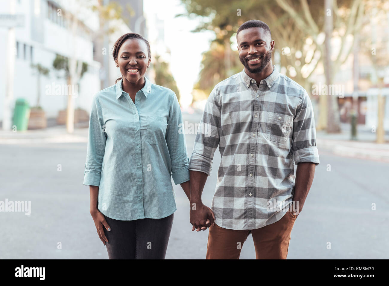 Young African couple smiling while holding hands in the city Stock ...