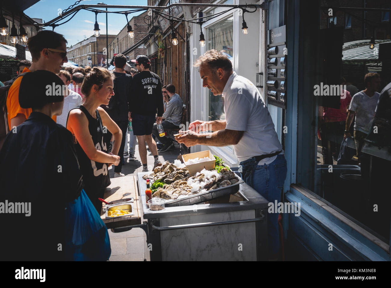 Man selling oysters in Broadway Market in East London (UK). August 2017. Landscape format. Stock Photo