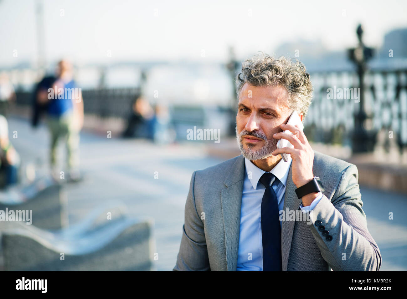 Mature businessman with smartphone in a city Stock Photo - Alamy