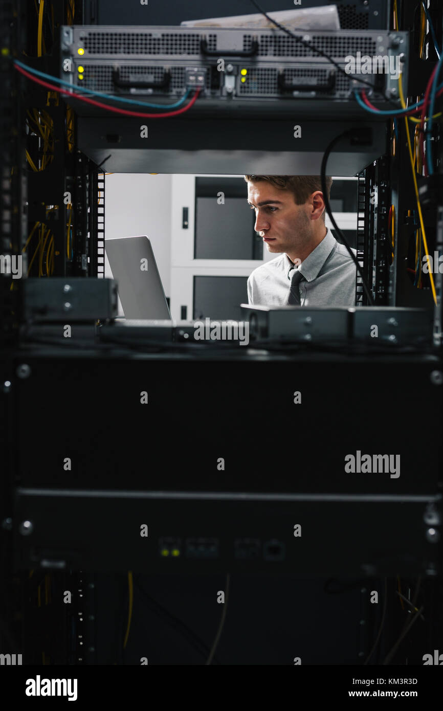 Young man is standing next to the racks with computer equipment Stock ...
